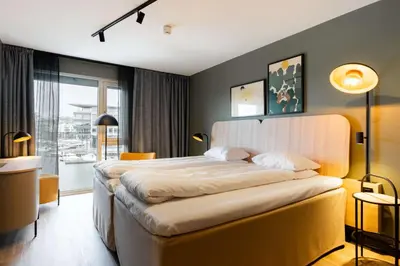 a bedroom with a large bed and a large window at Scandic Nidelven in Trondheim