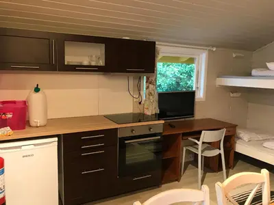 a kitchen with a table and a desk with a computer at Bergen Camping Park in Bergen