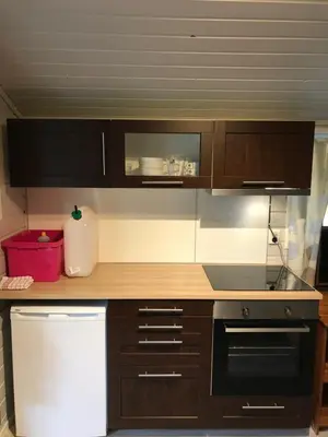 a kitchen with wooden cabinets and a stove top oven at Bergen Camping Park in Bergen