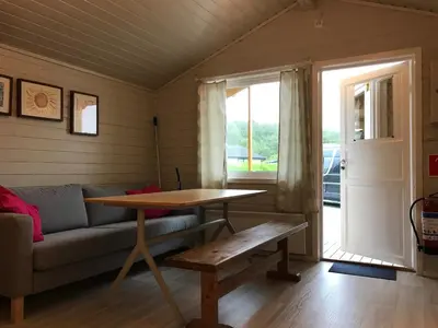 a living room with a couch and a table and a window at Bergen Camping Park in Bergen