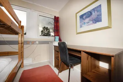 a bedroom with a desk and a bunk bed at Bergen Camping Park in Bergen