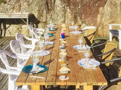 a long wooden table with glasses and shells on it at 6 person holiday home in Urangsvåg in Steinsbø