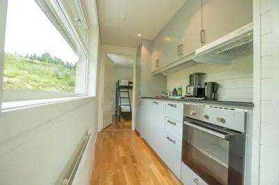 a kitchen with white cabinets and a window at Fjellsporthytta nr. 4 in Sogndal