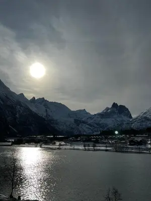 a large body of water with snow covered mountains at Frichs Ekspress Åndalsnes in Åndalsnes