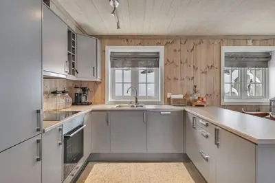 a kitchen with white cabinets and a sink at Kilen Lodge in Gaustablikk
