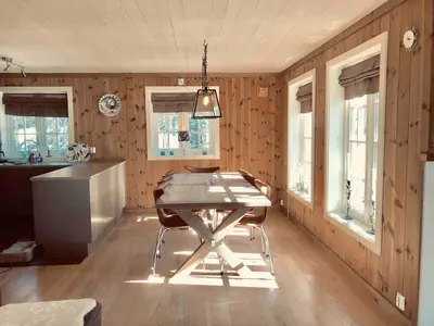 a dining room with a table and some windows at Kilen Lodge in Gaustablikk