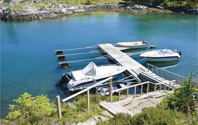 two boats are docked at a dock in the water at Gorgeous Home In Torangsvåg With Wifi in Skår