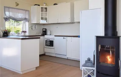 a kitchen with white cabinets and a stove at Gorgeous Home In Torangsvåg With Wifi in Skår