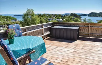 a patio with a table and chairs on a deck at Gorgeous Home In Torangsvåg With Wifi in Skår