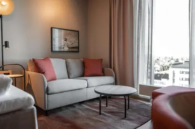 a living room with a couch and a window at Scandic Hamar in Hamar
