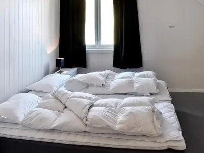 a large white bed in a room with a window at 10 person holiday home in skei i jølster in Årdal