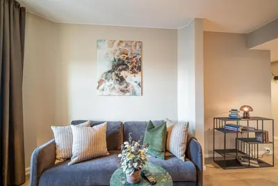 a living room with a blue couch and a table at Aksjemøllen - by Classic Norway Hotels in Lillehammer