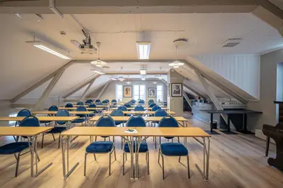 a classroom with tables and chairs in a room at Aksjemøllen - by Classic Norway Hotels in Lillehammer