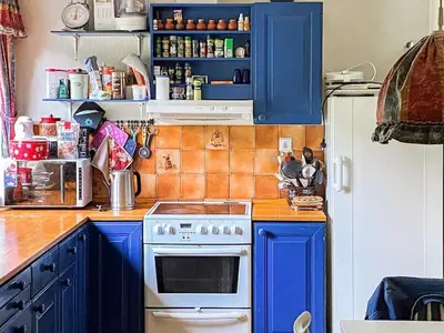 a kitchen with blue cabinets and a white stove at 9 person holiday home in Reksteren in Haukafer