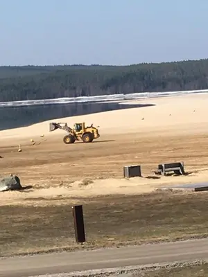 a bulldozer driving on a beach with a field at Osensjøen Camping in Valmen