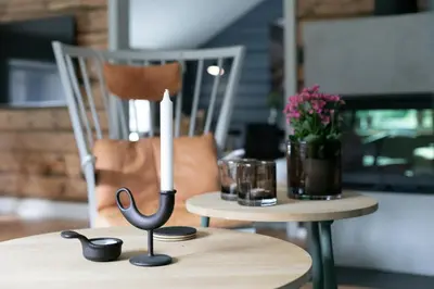 a candle on a table with a candle holder on it at Østigård 1810 in Åndalsnes