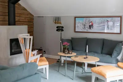 a living room with a couch and tables at Østigård 1810 in Åndalsnes