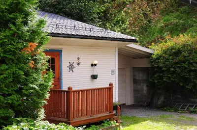 a small white house with a porch and a door at Visit Undredal in Undredal