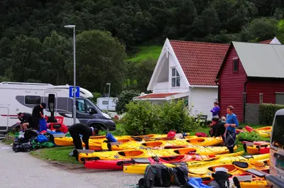 a group of kayaks are lined up in a yard at Visit Undredal in Undredal