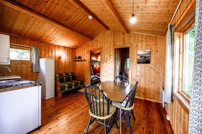 a kitchen and dining room with a table and chairs at Korsbakken Camping in Isfjorden