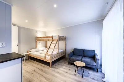 a bedroom with a bed and a blue couch at Korsbakken Camping in Isfjorden