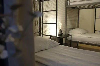 a bedroom with two beds and a window at Blue House Dormitory in Odda
