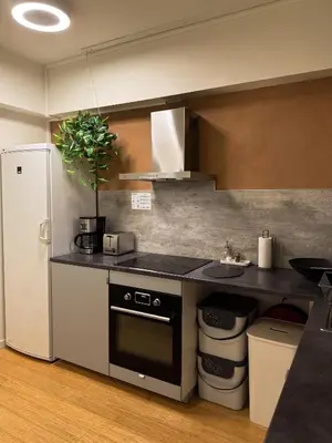 a kitchen with a white refrigerator and a sink at Blue House Dormitory in Odda