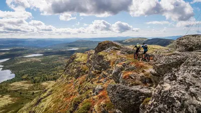 two people riding bikes on top of a mountain at Skjeggestad Gjestehus in Ringebu
