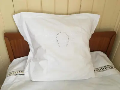 a white pillow with a heart embroidered on it at Skjeggestad Gjestehus in Ringebu