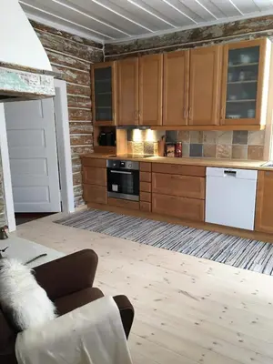 a kitchen with wooden cabinets and a white appliance at Skjeggestad Gjestehus in Ringebu