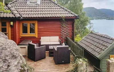 a house with a deck with chairs and a table at Nice Home In Valen With Wifi in Valen