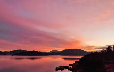 a sunset over a body of water with mountains at Nice Home In Valen With Wifi in Valen