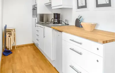 a kitchen with white cabinets and a wooden counter top at Stunning Apartment In Vossestrand in Vossestrand