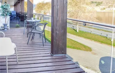 a wooden deck with a table and chairs on it at Stunning Apartment In Vossestrand in Vossestrand