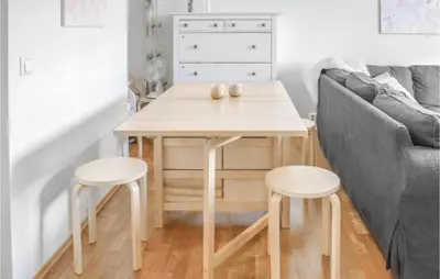 a table and stools in a living room with a couch at Stunning Apartment In Vossestrand in Vossestrand