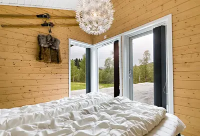 a bedroom with a large bed and a chandelier at Riverside in Hornindal