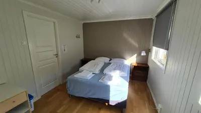 a bedroom with a bed with white sheets and pillows at Trolltunga Lodge in Odda