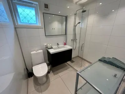 a bathroom with a toilet and a sink and a shower at Trolltunga Lodge in Odda