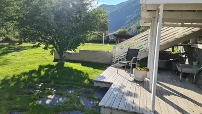 a porch of a house with a table and a chair at Trolltunga Lodge in Odda