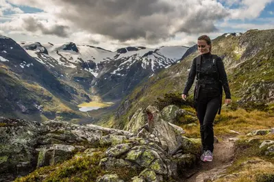 a woman walking on a trail in the mountains at Rolfhytta - Fosskamben 19 in Sogndal