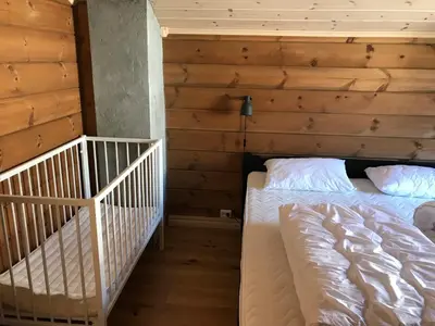 a bedroom with a crib in a log cabin at Harpefossen Skisenter og Hyttegrend in Nordfjordeid