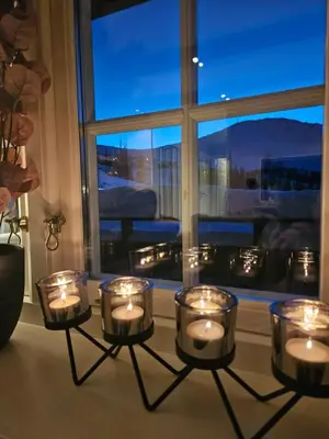 a group of candles on a table in front of a window at Leilighet Gaustablikk in Rjukan