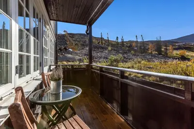 a balcony with a table and chairs and a view at Leilighet Gaustablikk in Rjukan