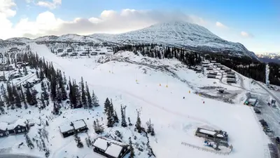 a snow covered mountain in front of a ski slope at Leilighet Gaustablikk in Rjukan