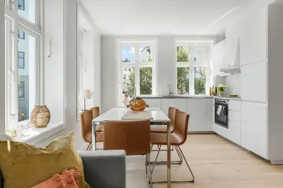 a kitchen and dining room with a table and chairs at Barfot Apartments in Bergen