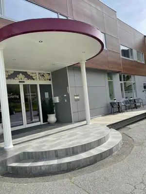 a building with a spiral staircase in front of a building at Hotell Koselig in Kyrksæterøra