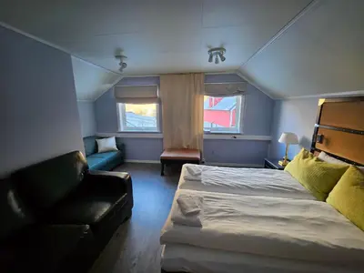 a small bedroom with a bed and a couch at Fossen Accommodation in Geiranger