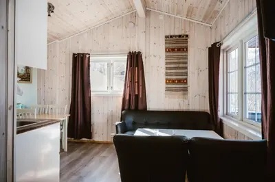 a living room with a couch and a kitchen at Fossen Accommodation in Geiranger