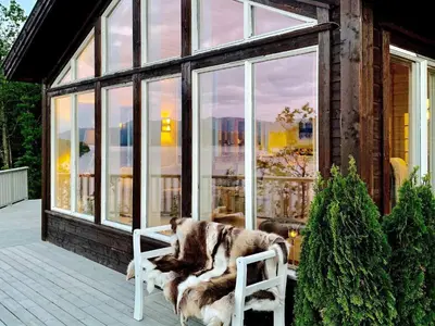 a dog sitting on a chair on a porch at Serene Waterfront Retreat-By Traum in Valevåg