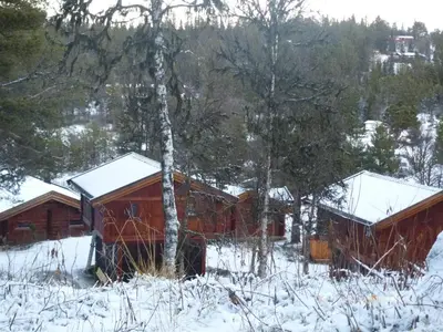 two cottages in the snow in the woods at Måsåplassen Friisvegen Mountain Lodge in Ringebu